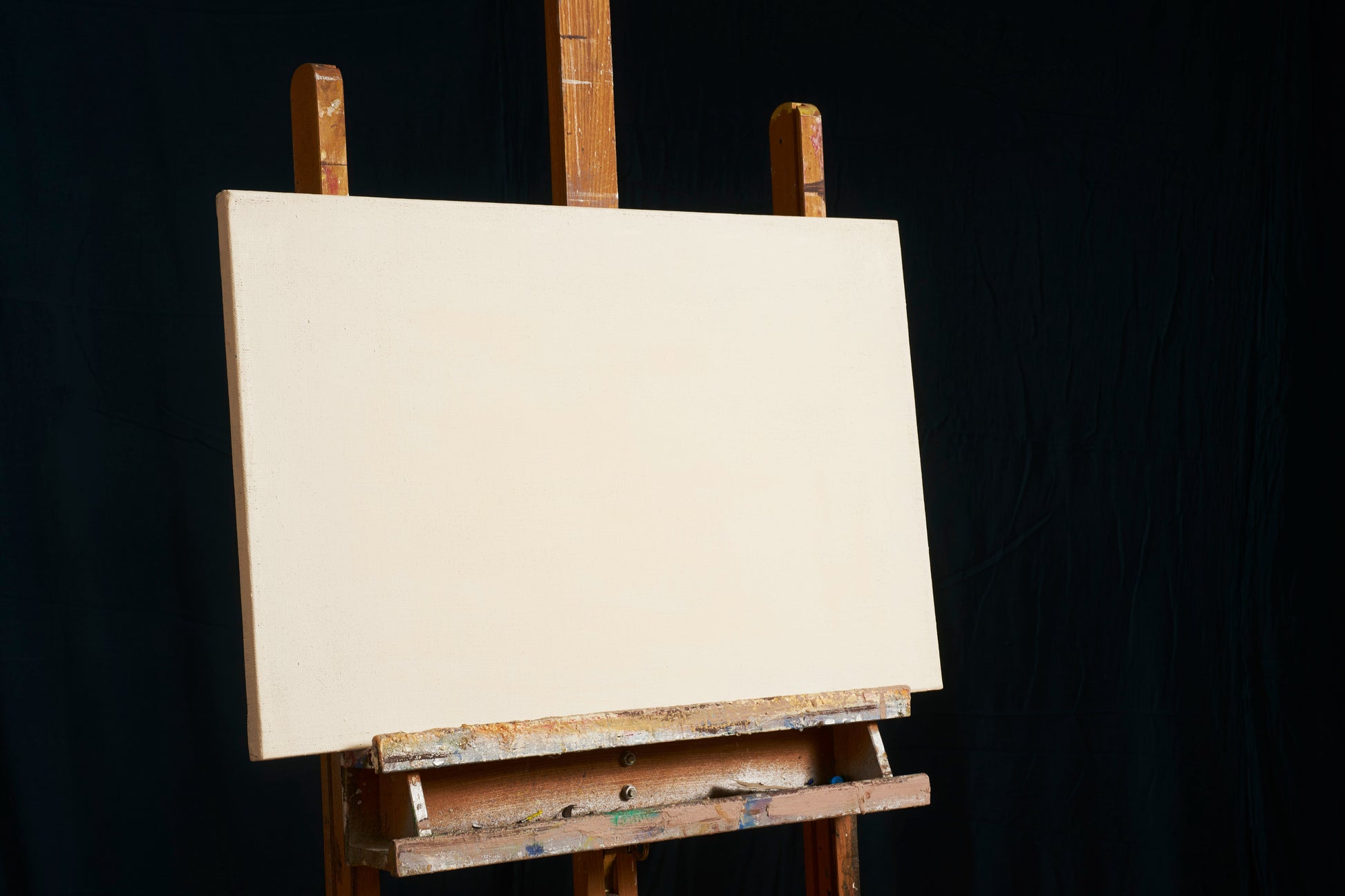 Blank canvas on easel in artist’s studio, symbolizing the start of a custom art commission